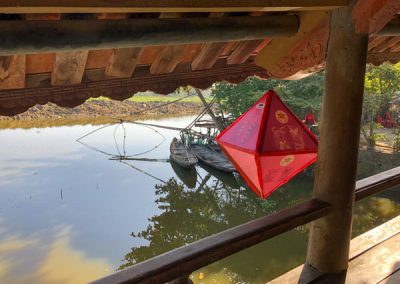 Ein Lampion hängt am Dach der Brücke, im Hintergrund ein Fluss