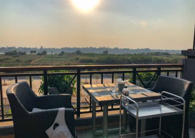 Tiefstehende Sonne über dem Mekong von einer Dachterrasse aus