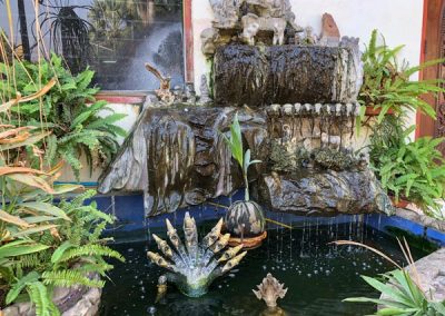 Wat That Luang Tai - Brunnen mit Figuren im Garten
