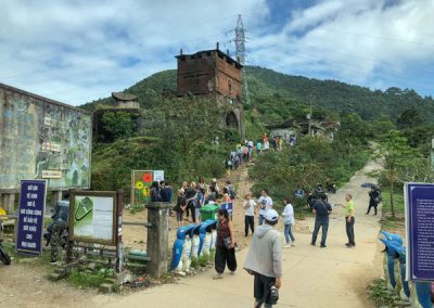 Viele Touristen vor einem Hügel mit einem alten Ziegeltor und weiteren Geschützstellungen aus dem Vietnamkrieg