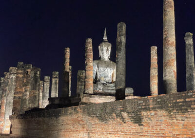 Beleuchtete Buddha-Statue bei Nacht.